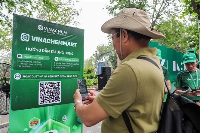 A man scans the QR code of e-commerce platform VinachemMart at the launch on May 10. (Photo: VNA)