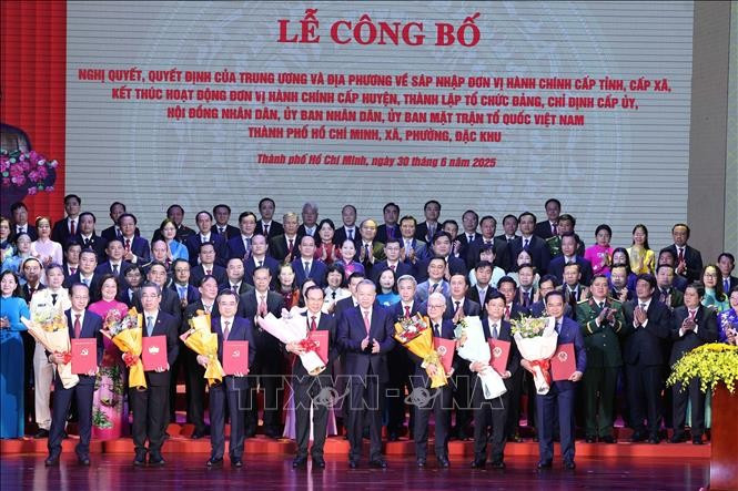 Party General Secretary To Lam (front, fifth from left) presents the resolutions and decisions on the merger of administrative units, the establishment of Party organisations, and the appointment of personnel at the ceremony in HCM City on June 30. (Photo: VNA)