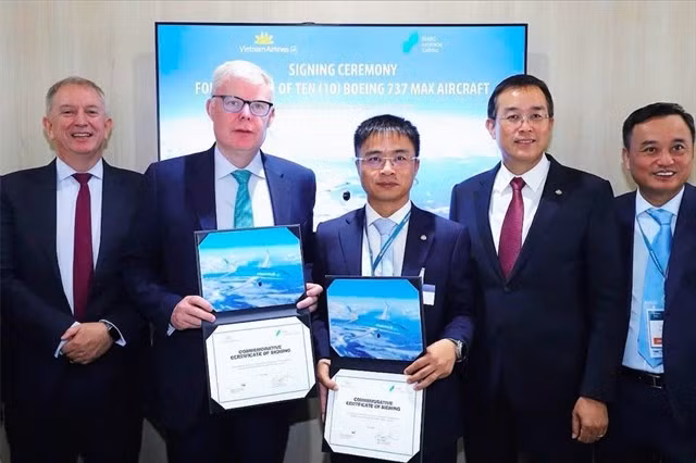 EVP of Vietnam Airlines Nguyen Chien Thang and SMBC Aviation Capital Chief Commercial Officer Barry Flannery exchange signed agreements in the presence of senior executives from both parties. (Photo courtesy of Vietnam Airlines)