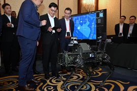 Deputy Prime Minister Heng Swee Keat (centre) trying to control the legged robot using DSTA's robotics-enabled C3 at the Singapore Defence Technology Summit on March 19. (Photo: https://www.straitstimes.com/)