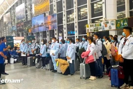 Vietnamese labourers wait for boarding at an airport. (Photo: VietnamPlus)