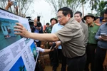 Prime Minister Pham Minh Chinh reviews the plan for building flood-resistant houses for residents in flood-affected areas. Photo: VNA