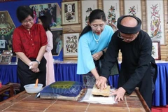 Visitors to Bac Ninh try making a Dong Ho folk painting. (Photo: VNA) 