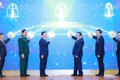 Prime Minister Pham Minh Chinh (third from right) and officials launch the Ministry of Construction’s new information technology systems at the conference on December 21. (Photo: VNA)