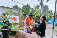 A representative of the Vietnam Red Cross Society delivers relief to a flood-hit resident in Hue city. (Photo: VNA)