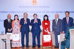 PM Pham Minh Chinh (centre) presents gifts to the Vietnamese community in Russia at the meeting in Moscow on late March 22 (local time). (Photo: VNA)