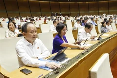 Deputies press buttons to vote on laws and resolutions at the 15th NA's 9th session. (Photo: VNA)