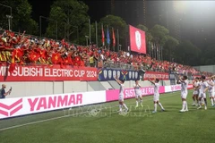 Vietnamese footballers celebrate the win at their ASEAN Cup first semi-final against Singapore on December 26 night. (Photo: VNA)