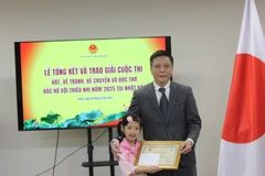 Kim Tra My (left), a contestant, receives a certificate from the Vietnamese Embassy in Japan. (Photo: VNA)