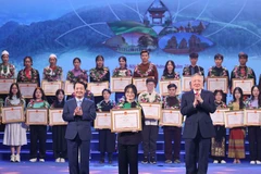 Permanent Deputy Prime Minister Nguyen Hoa Binh (front, right) and Minister-Chairman of the Committee for Ethnic Minority Affairs Hau A Lenh (front, left) present certificates of merit to ethnic minority students and youths at the ceremony on December 28. (Photo: VNA)