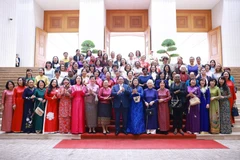 Prime Minister Pham Minh Chinh, his spouse, and Vietnamese and international female diplomats at the meeting in Hanoi on July 10, 2025. (Photo: VNA)