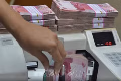 Indonesian rupiah banknotes are counted at a foreign exchange office. (Photo published by VNA)