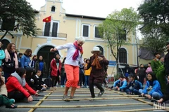Foreign tourists enjoy a folk cultural activity in Hanoi (Photo: Nhan dan Newspaper)