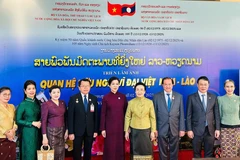 Madame Ngo Phuong Ly (fifth from left), Madame Naly Sisoulith (sixth from left), and officials of the two countries at the opening ceremony of the Vietnam Film Week and the photo exhibition on December 2 (Photo: The thao & Van hoa newspaper)
