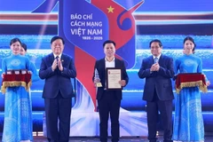 PM Pham Minh Chinh (second from right) and Chairman of the Party Central Committee's Commission for Information, Education and Mass Mobilisation Nguyen Trong Nghia (second from left) present an award to a representative of VietnamPlus reporters at the ceremony on June 21. (Photo: VNA)