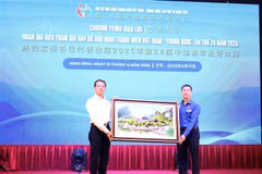 Secretary of the Ninh Binh provincial Youth Union Trinh Nhu Lam (right) presents a painting of the Trang An landscape to a representative of the Chinese youth. (Photo: VNA)