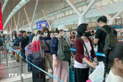 Passengers wait to handle boarding procedures at Tan Son Nhat International Airport. (Photo: VNA)