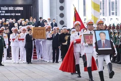 The portrait and coffin of former State President Tran Duc Luong are transferred to the hearse following the memorial service at the National Funeral Hall in Hanoi on May 25 morning. (Photo: VNA)