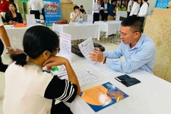 A business representative gives information to a job seeker. (Illustrative photo: VNA)