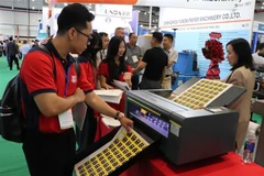 Visitors learn about stamp printing technology at the Vietnam International Paper and Packaging Exhibition 2025 (Photo: VNA)