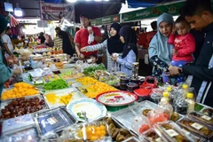 Consumers buy food at a market in Narathiwat province of Thailand. (Photo: AFP/VNA)