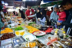 People buy food at a market in Narathiwat province of Thailand. (Photo: AFP/VNA)