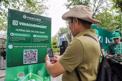 A man scans the QR code of e-commerce platform VinachemMart at the launch on May 10. (Photo: VNA)