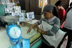 A consumer buys rice at a market in Manila, the Philippines. (Photo: Xinhua/VNA)