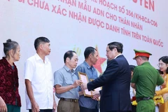PM Pham Minh Chinh presents the announcements of martyrs' DNA testing results to representatives of families at the conference on July 25. (Photo: VNA) 