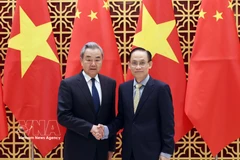 Vietnamese Politburo member and Minister of Foreign Affairs Le Hoai Trung (right) welcomes Chinese Politburo member and Minister of Foreign Affairs Wang Yi in Hanoi on March 15. (Photo: VNA)