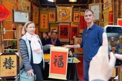 International visitors experience the traditional new year calligraphy activity (Photo: VNA)