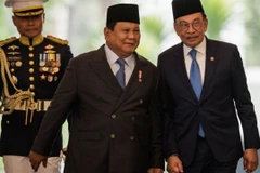 Malaysia's Prime Minister Anwar Ibrahim (right) and Indonesia’s President Prabowo Subianto (centre) walk together ahead of their bilateral meeting at the Presidential Palace in Jakarta on July 29. (Photo: AFP/VNA) 