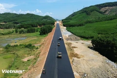 Contractors lay asphalt concrete on the roadbed of the Quy Nhon–Chi Thanh Expressway project. (Photo: VietnamPlus) 