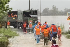 Forces and specialised vehicles advance further into flood-hit Hoa Thinh commune to support relief efforts. (Photo: VNA)