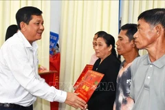 Secretary of the Vinh Chau Township Party Committee Duong Sa Kha hands over the token of new homes to underprivileged families. (Photo: VNA)