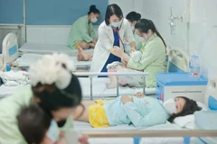 A doctor tends to a child patient infected with COVID-19 at the Thanh Nhan Hospital in Hanoi. (Photo: VietnamPlus)