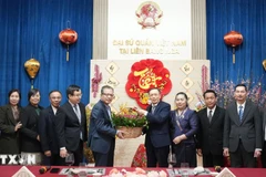 Vietnamese Ambassador Dang Minh Khoi and Lao Ambassador Shiphandone Oybuabuddy with officials and staff of the two embassies. (Photo: VNA) 