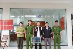 Trinh Quoc Phu (centre) voluntarily hands over a rare forest night heron to the police and authorities of Quy Nhon Nam ward. (Photo: baogialai.com.vn) 