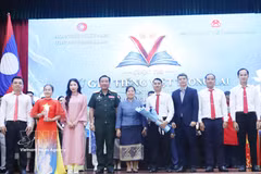 Representatives of the Vietnamese Embassy in Laos and the Lao Ministry of National Defence present the third prize to a winning team at the "Future Vietnamese Language Ambassadors" contest in Vientiane. (Photo: VNA) 