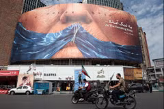 Motorists ride past an anti-US billboard referring to President Donald Trump and the Strait of Hormuz at Valiasr Square in Tehran on May 2, 2026. ( Photo: AFP) 