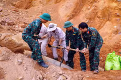 A MAG explosive ordnance disposal team, in coordination with Bo Trach commune's Military Command, safely handles an unexploded bomb for transport to a disposal site. (Photo: VNA) 