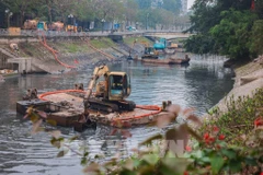Vehicles and equipment are deployed to dredge a river in Hanoi. (Photo: VNA)