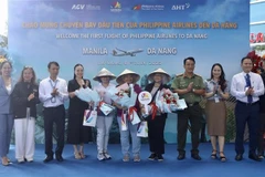 Presenting flowers and gifts to first passengers arriving in Da Nang on direct Manila–Da Nang flight. (Photo: VNA) 