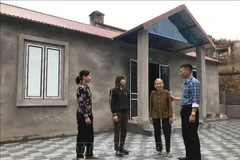 Local officials visit and encourage a family after they move into their new home under Hai Duong’s temporary and dilapidated housing eradication programme. (Photo: VNA)
