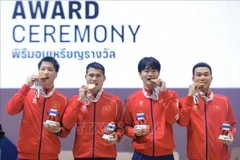 Fencing athletes Nguyen Xuan Loi, Nguyen Van Quyet, Le Van Bang, Phan Anh Duong dominate Malaysia 45–27 in the team final to win gold. (Photo: VNA)