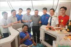 Leaders of the Vietnam Football Federation, coaches and striker Xuan Son and a member of cabin crew pose for a photo. (Photo: VNA)