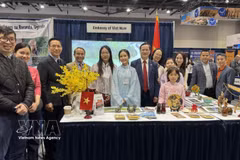 Ambassador Pham Vinh Quang (seventh from left) poses for a photo with staff of the Vietnamese Embassy in Canada at the Vietnam booth at the exhibition. (Photo: VNA) 