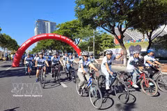 Delegates take part in a cycling event to promote a green lifestyle message. (Photo: VNA) 