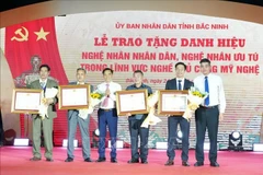 Leaders of the Ministry of Industry and Trade and the Bac Ninh Department of Industry and Trade present the title of Meritorious Artisan to outstanding individuals. (Photo: VNA) 