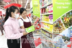 Consumers shop at a supermarket. (Illustrative photo: VNA)